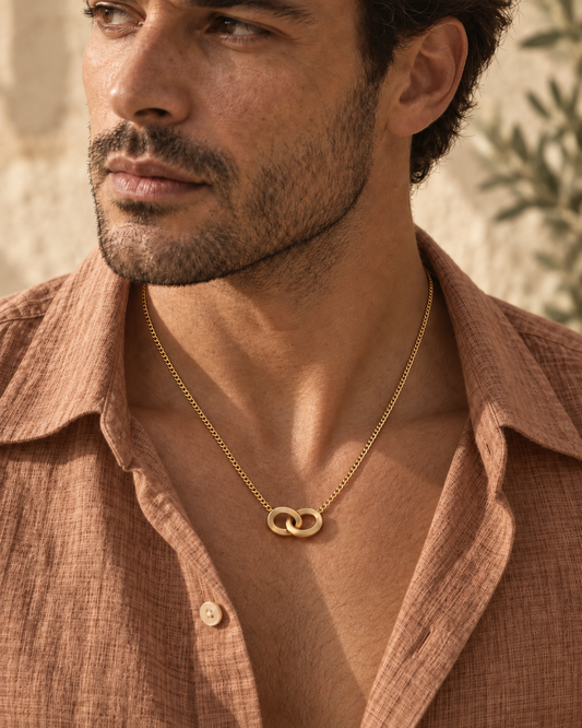 Man in a terracotta linen shirt wearing the AEQUORO Heavy Pendant in 18k yellow gold